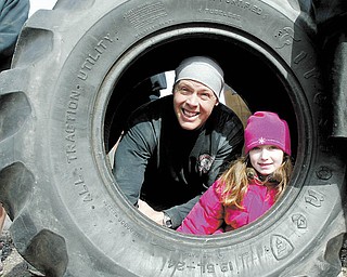 Ironman Warehouse gym is moving from Wilson Ave to downtown Youngstown. Owners and friends carried logs, tires and and other workout equipment the 1.8 miles to the new location. Owner Paul "Dunner" Dunleavy and his niece Jillian Dunleavy look out of one of the tires used for workouts at the gym.