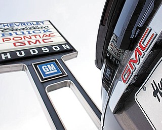 In this Feb. 7, 2010 photo, a 2010 GMC Acadia sits under the sign at a General Motors dealership in Silverthorne, Colo. General Motors Co. said Thursday, April 1, 2010, its March sales rose 21 percent over the same month last year, a sign that an incentive war will boost overall U.S. auto sales.