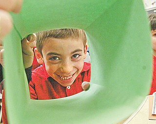 Petros Atsas peers through a folded piece of paper that was to become an Easter basket.