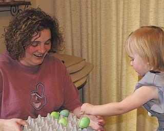 While visiting her grandparents, Mike and Laurie Fox of Lowellville, 2-year-old Ashlynn Mason enjoyed coloring eggs and sharing them with her mom, Beth..