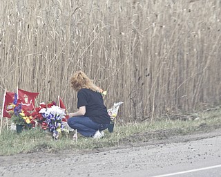 LISA-ANN ISHIHARA | THE VINDICATOR -- Mourner lays flowers at the site of the fatal crash that took the lives of 3 marine recruits last week