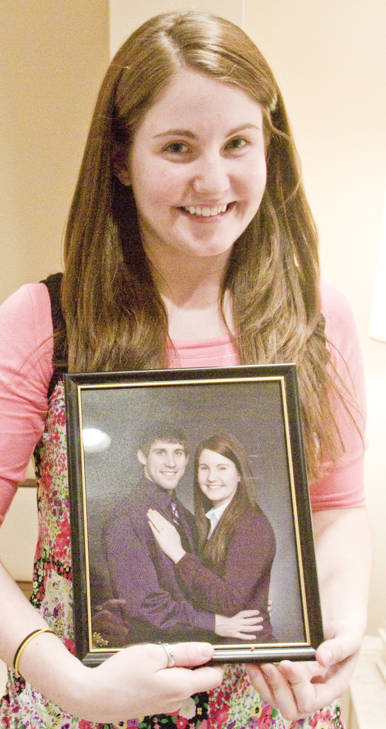 LISA-ANN ISHIHARA | THE VINDICATOR -- Fiance Angel Willis holds her favorite engagement of herself and Michael Theodore  at his calling hours at Peter Rossi & Son , one of three victims in fatal accident last week.