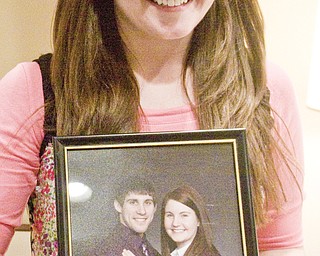 LISA-ANN ISHIHARA | THE VINDICATOR -- Fiance Angel Willis holds her favorite engagement of herself and Michael Theodore at his calling hours at Peter Rossi & Son , one of three victims in fatal accident last week.