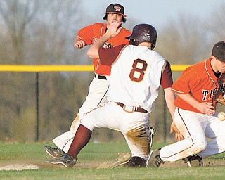 eld’s Cody Pitzo watches as South Range’s Andy Lacefi eld (8) arrives safely at second as the Tigers’ Ronnie Bovo (11) bobbles the ball during the sixth inning of Tuesday’s game at the new South Range High School in North Lima. The Raiders defeated the Tigers 13-6.