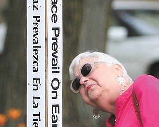 Mary Lou Finesilver reads the various languages on the Peace Pole outside Boardman Center Middle School, Market Street. The memorial pole was dedicated in a Wednesday morning service to Holocaust survivor Bill Vegh, who died in June. Vegh was a frequent speaker to Boardman students about his experience. The ceremony
featured a presentation by Eva Schloss, also a Holocaust survivor. After the Holocaust, Schloss’s mother married Otto Frank, the father of Anne Frank.