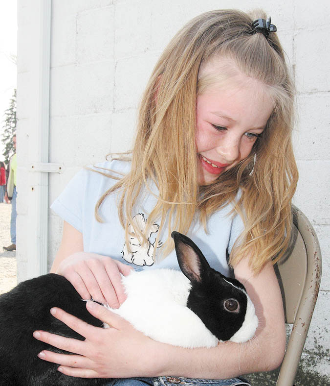 FARM - 8 year old Autumn Reed of Boardman cuddles with a rabbit Sunday afternoon. - Special to The Vindicator/Nick Mays