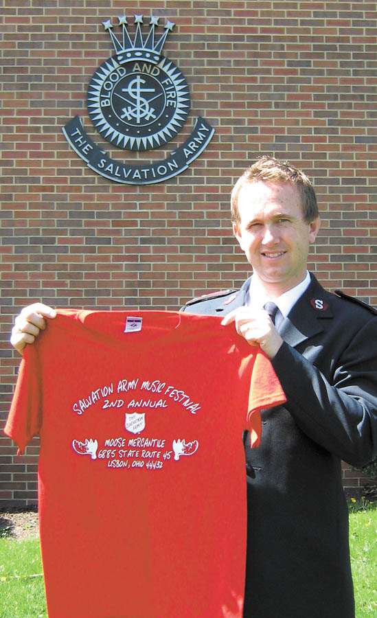 The Vindicator: Captain John Brand of the Salvation Army in Salem  on  .Monday displays a shirt being sold to help raise funds for the needy  .next Christmas while standing by the army's large kettle..