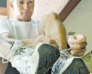 Atty. James Dietz ties his running shoes before training in downtown Youngstown. He is training for his
fi rst Boston Marathon and trying to raise at least $10,000 via 2010 Boston “Jack Rabbit” Marathon.