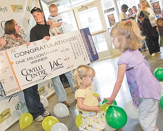 Alexis and Madison Beaudis, ages 2 and 4, play among balloons that fell from the ceiling as Jessica and Adam Hayes along with their 1-year-old son Caiden were recognized at the Covelli Centre as the 1 millionth patron Tuesday evening.