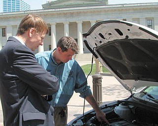Ohio Attorney General Richard Cordray, left, listens as David Green, president of United Auto Workers Local 1714 in Lordstown, describes the inside of a Chevrolet Cruze at an Earth Day press conference in front of the Statehouse.