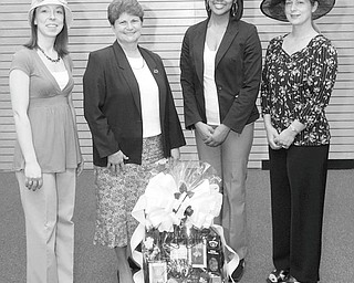 MARK STAHL | THE VINDICATOR: Among the fun-filled events that will take place during a Kentucky Derby party to be sponsored by the Junior League of Youngstown will be a basket raffle and a hat contest. Showing some of the hats that may be seen at the contest and one of the baskets are, from left, Kelly Kiraly, co-chairwoman; Susan Stewart, chairwoman; and Kere Thompson and Marion Dunham, committee members.