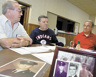 Photographs of Army Specialist 5 John Mirich, are spread out on table while Mirich’s brothers, from left, George,
Louis and Stephen Mirich Sr., talk about him. John Mirich was the youngest boy of 13 children. He was killed on
Jan. 16, 1969, in Binh Duong, South Vietnam, during the Vietnam War.