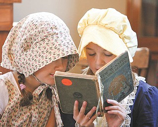 Rachel Wolfe and Katie Masucci read from old school books as second graders from Union Elementary School,
Poland, spent Wednesday at the Little Red Schoolhouse on U.S. Route 224 to see how children their age learned many years ago.