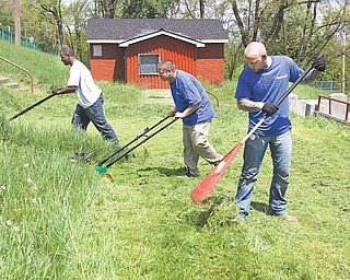 Officials with eight regional Walmart stores, along with members of 100 Black Men of Greater Youngstown/Warren, the Youngstown city schools, Warriors Inc., Mahoning County High School and the Youngstown Parks and Recreation Department, took part in cleaning up Gibson Field on Youngstown’s South Side. From left are Mark Callion of Warren; Michael Cappitte, a Chaney High School sophomore; and Kevin Bryson from a Walmart store in East Liverpool. The cleanup was Tuesday.
