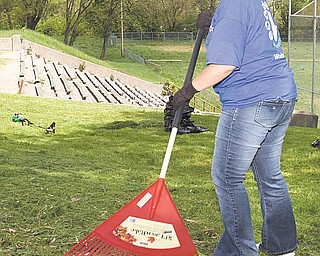 Shauna Desenze, a volunteer from the East Liverpool Walmart, helps clean up the field, long used for sandlot baseball games. Now, the field will be used for flag-football games.