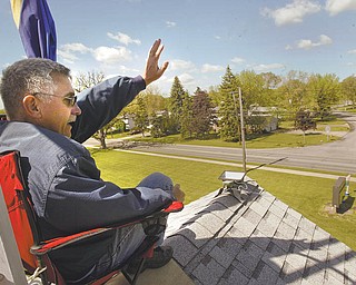 Barry Knaub, pastor of Central Baptist Church in Niles, waves to motorists passing and honking their horns in
response to signs at the church on North Road to beep for prayers. He spent 12 hours on the church rooftop Thursday.