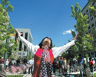 Under sunny, blue skies, Andrea Morvay of Youngstown, dressed in patriotic fashion, dances and prays during the National Day of Prayer observance Thursday in downtown Youngstown. The event ws coordinated by the City Prayer Team of Youngstown. Jonathan Moore, senior pastor at Highway Tabernacle, was keynote speaker.