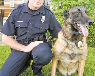 Boardman Police Officer Brian Cionni poses with his newly retired police dog Robby. The Belgian malinois has
been on the force working with Cionni for about eight years, but last month Robby entered retirement. He even
sports a retirement badge to prove it. Cionni has purchased Robby for $1 from the police department
and plans to keep him as his personal pet.