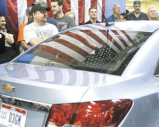 A group of GM Lordstown employees gathers around a Chevrolet Cruze after a benefit motorcycle ride through the plant. Production of the Cruze is expected to begin at the plant in July.