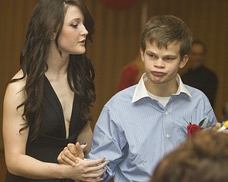LISA-ANN ISHIHARA | THE VINDICATOR...Lindsay Lewis, 17, helps her brother Nick Lewis, 16, Canfield., at the annual tri county special needs prom, held at Anthone's.