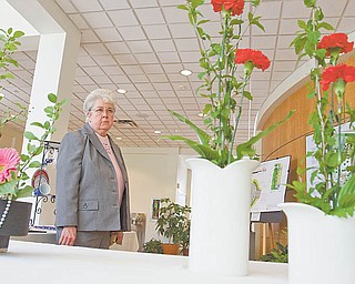 Sister Mary Cunningham of Youngstown looks at floral arrangements Sunday at the Garden Forum Spring Flower Show in Fellows Riverside Gardens in Mill Creek MetroParks. The center also hosted a dahlia show Sunday.