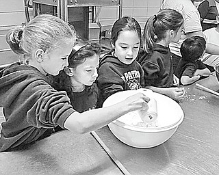 Students in Mrs. Mellony Leonard’s second-grade class at St. Patrick School in Hubbard prepare for their First Communion by baking bread for the important day. The bread-making has become a tradition at the school, where these students began the process by mixing the ingredients. Other students shared the mixing, kneading and baking, and at the end of the day, each ate some of the bread, took a loaf home and saved special loaves to present at the communion Mass.