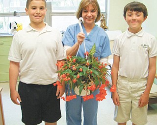 During Nurse Appreciation Day on May 6, students and staff at St. Patrick School in Hubbard presented a Begonia plant in a hanging basket to the school nurse, Joan Humphry, who is always there to bandage a knee, listen to a problem or give out “magic mints” that heal all wounds. Shown during the presentation are, from left, Kent Kyronovich (fifth grade), nurse Humphry, and Julian Maiorano, (fourth grade).