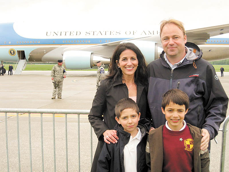  A steel barrier seperates Joe and Judy Kordupel of Boardman, their son Joey, right, and nephew Noah Pecchia, left, from Air Force One along the tarmac at the Youngstown Air Reseve Station in Vienna. The family eagerly awaited a tour on the airplane that brought President Barak Obama to the region to discuss the economy and the V and M Star expansion. Photo by Doug Livingston.