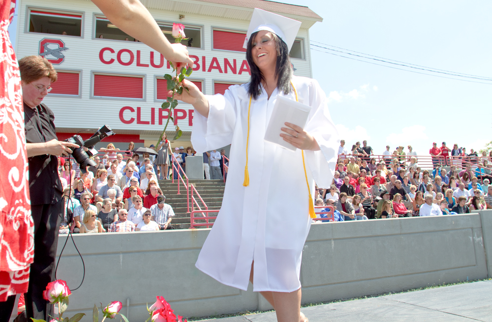Geoffrey Hauschild|The Vindicator.Graduate, Lauren Houck, receives her diplomia and a flower which students later presented to a loved one in the crowd during Columbiana High School's 2010 Commencement Ceremony at Firestone Park on Sunday afternoon.