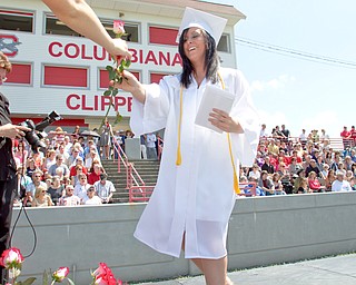 Geoffrey Hauschild|The Vindicator.Graduate, Lauren Houck, receives her diplomia and a flower which students later presented to a loved one in the crowd during Columbiana High School's 2010 Commencement Ceremony at Firestone Park on Sunday afternoon.