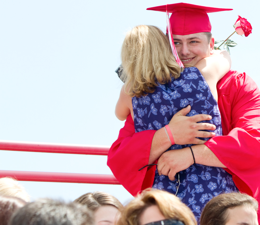 Geoffrey Hauschild|The Vindicator.Graduate, Michael McMaster, gets a hug after presenting his mother, Carrie McMaster, with a flower during Columbiana High School's 2010 Commencement Ceremony at Firestone Park on Sunday afternoon.