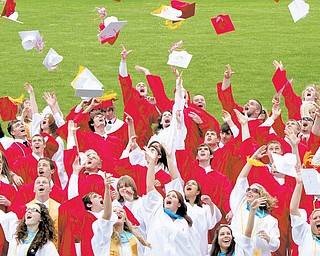 The graduates of Columbiana High School show their excitement at completing their senior year as they toss their caps into the air during commencement exercises Sunday at Firestone Park. Mother Nature provided a beautiful warm, sunny day for the event. This year's senior class had 66 members. As part of the ceremony, students presented red roses to the person who most helped them succeed.