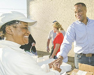 The Vindicator Mayor Jay Williams greets Lillie Caffey of Youngstown during a Monday morning event to observe the 99 th anniv of St. PAtrick church. The church gave away free donuts and coffee Monday morning along Market St in Youngstown.