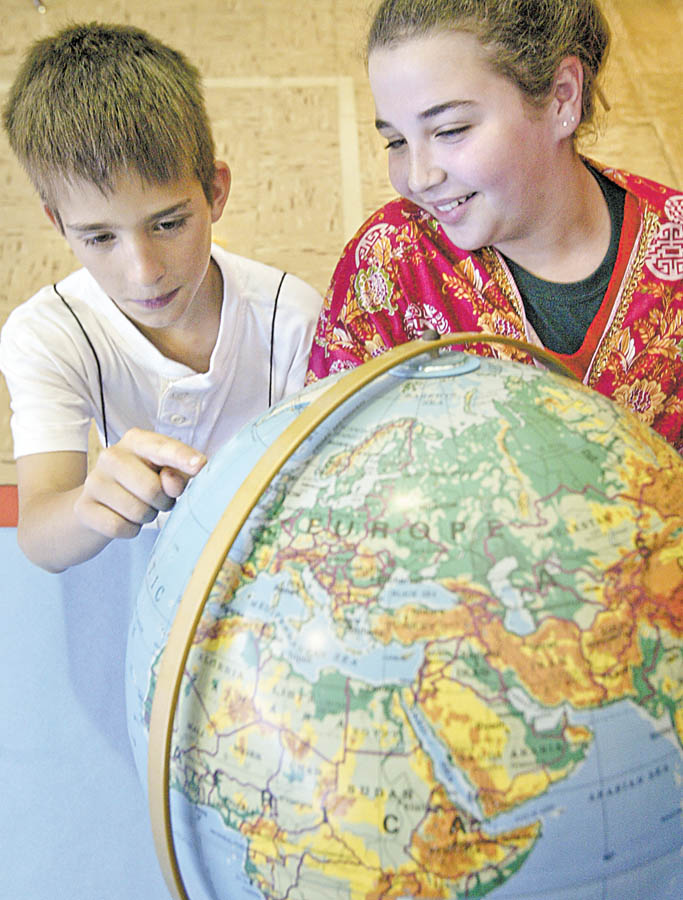 Ryan Kost and Emily King look a globe during a “Country Extravaganza” on Tuesday at South Side Middle School.