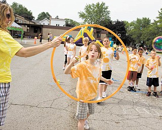 St. Charles fourth-grader Claire Driscoll plays bubble chase with her classmates during the picnic Wednesday at the school. Sponsored by the Home & School Association, the picnic included food, games, music and other activities for the children.