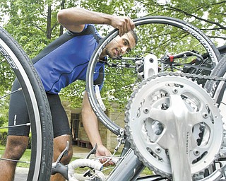 Jose Medina, co-director of 4K for Cancer, checks his bike at Westminster Presbyterian Church in Boardman on Thursday after riding from Butler, Pa. 4K for Cancer, a nonprofit group of 28 bicyclists, is traveling 4,000 miles, starting in Baltimore earlier this week and ending July 31 in San Francisco.