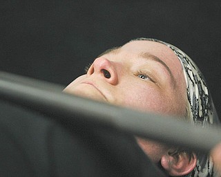 Chelsi Figley grimaces as she practices the bench press. The 27-year-old East Palestine resident, who is afflicted with spina bifi da, will compete in the Paralympic Games in Malaysia later this year.