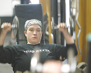 Chelsi Figley grimaces as she practices the bench press. The 27-year-old East Palestine resident, who is afflicted with spina bifida, will compete in the Paralympic Games in Malaysia later this year.