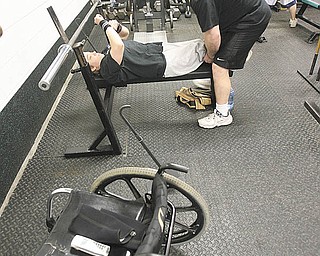 Chelsi Figley’s personal trainer Brian Raneri does more than provide workout motivation. He also helps the
Paralympian weightlifter move from her wheelchair into position on the bench.