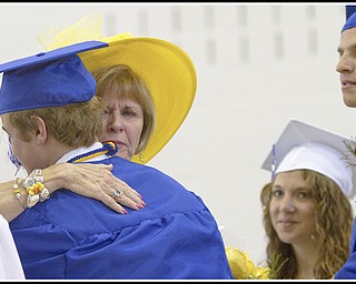 Geoffrey Hauschild|The Vindicator.Retiring teacher, Barbara Stacy, hugs a Poland graduate alongsie fellow graduates, Danielle Sabelli (second from right) and Andrew Bartos (right), during Poland's 2010 Commencement Ceremony at the high school gymnasium on Sunday afternoon.