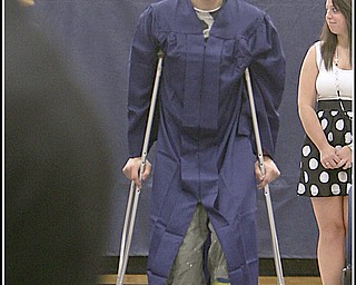 ROBERT K. YOSAY | THE VINDICATOR..putting his best foot forward at graduation .. even if its in a cast is Kyle Gump as he makes his way to his seat at Lowellville High School gym - the glass of 2010 - graduated Sunday afternoon-30