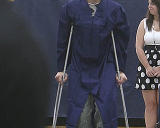 ROBERT K. YOSAY | THE VINDICATOR..putting his best foot forward at graduation .. even if its in a cast is Kyle Gump as he makes his way to his seat at Lowellville High School gym - the glass of 2010 - graduated Sunday afternoon-30
