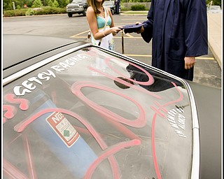 ROBERT K. YOSAY | THE VINDICATOR...Almost ready as Jeff Getsy picks up his graduation cap held by Amanda Pesta ( girlfreind) - Getsy came with 2010 written o his racing 77 Vega. at Lowellville High School gym - the glass of 2010 - graduated Sunday afternoon-30
