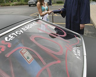 ROBERT K. YOSAY | THE VINDICATOR...Almost ready as Jeff Getsy picks up his graduation cap held by Amanda Pesta ( girlfreind) - Getsy came with 2010 written o his racing 77 Vega. at Lowellville High School gym - the glass of 2010 - graduated Sunday afternoon-30