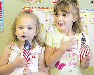 Clara Carriocce, left, and Michelle Queen, both 4, recite the Pledge of Allegiance at Lads ‘N Lassies. Today is National Flag Day, established by Congress in 1949 to commemorate the anniversary of the adoption of the U.S. flag in 1777.