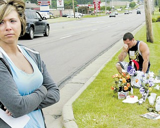 Ashley Bleggi, girlfriend of Nicholas Stubler, a motorcyclist killed in a weekend crash on South Avenue, Boardman, pauses at a roadside memorial at the crash site. Jamie Milsom of Leetonia, a friend of Stubler's, pays his respects in the background.