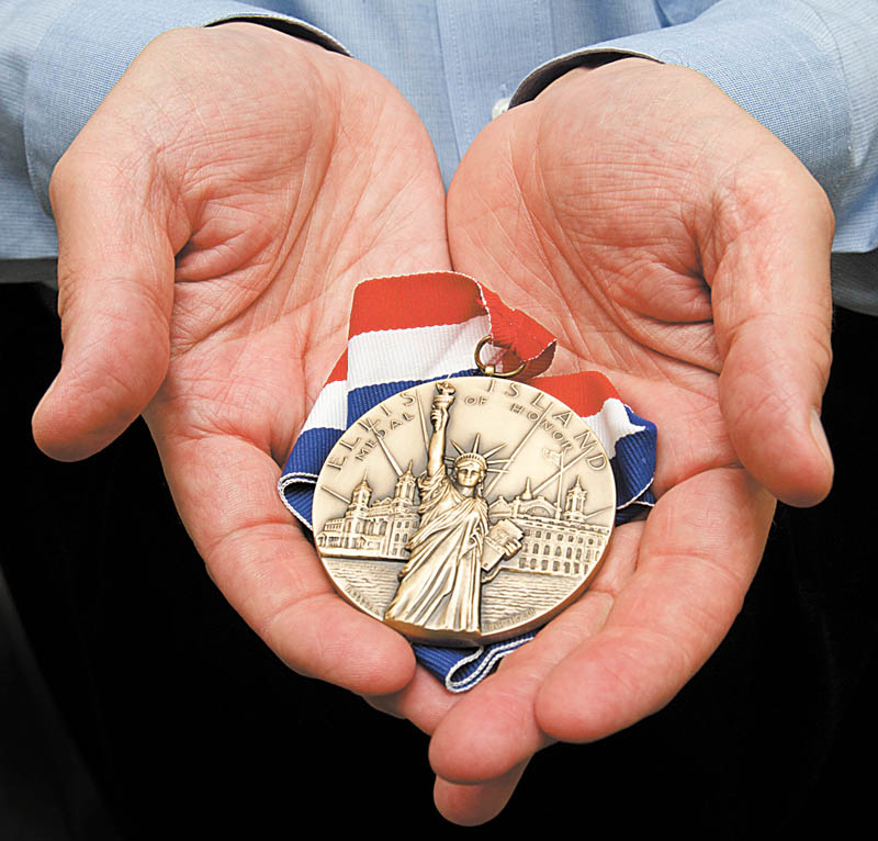 Tom Cook holds his 2010 Ellis Island Medal of Honor.