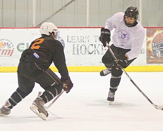Dylan Margonari (12) successfully scores a goal past Jordan Young (2) during the first period of a scrimmage at the Ice Zone on Tuesday evening.