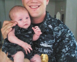 Christopher Holtzman, formerly from Poland and now stationed at Naval Air Station in Pensacola, Fla., holds his newborn son, Christopher.