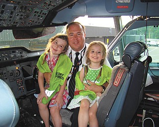 Todd Tobey of Boardman, who is an airline pilot, and his daughters, Madelyn and Natalie, are sitting in the cockpit of an Airbus A-300 jumbo jet on "Take Your Daughters to Work Day."